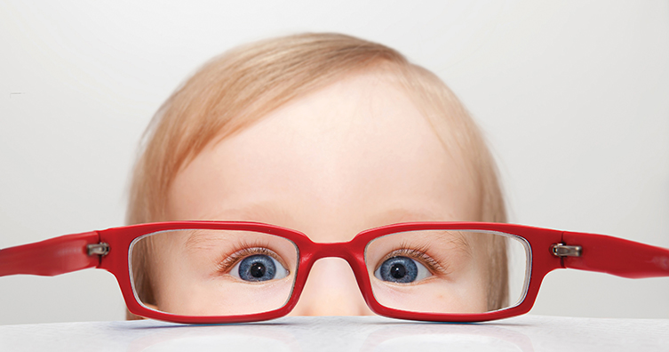 Small child peeping over table - read glasses